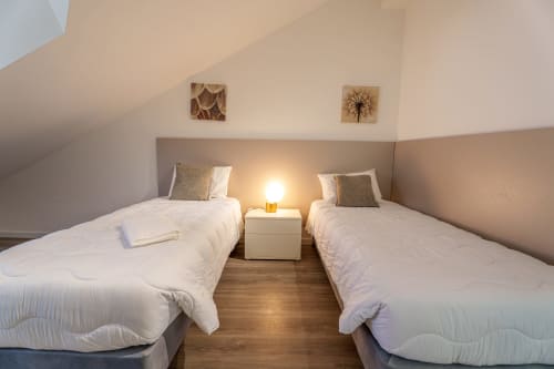 Twin bedroom with white bedding at Suites Avenue Lux Apartments in Horta, Faial, Portugal