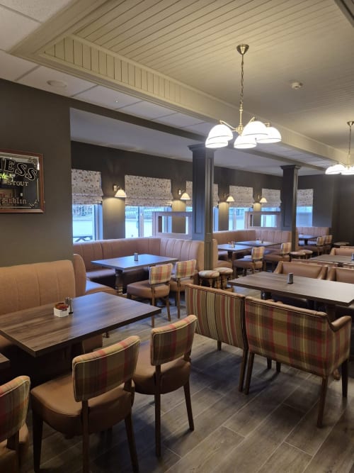 Sliabh Beagh Hotel dining area with booths, striped chairs, wooden tables, and pendant lighting in Monaghan.