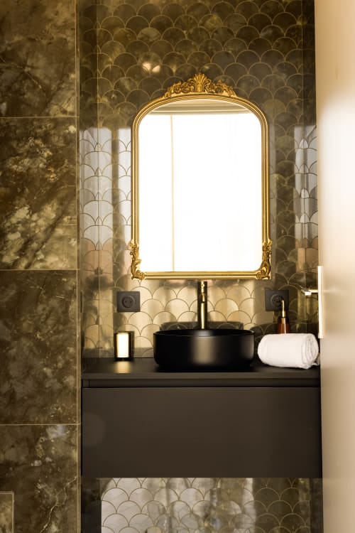 Salle de bains luxueuse de l'Hôtel Villa Martini à Ajaccio avec miroir doré orné, vasque noire et dosseret en carrelage écaille
