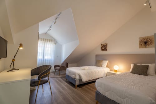 Modern attic bedroom at Suites Avenue Lux in Horta with twin beds, skylights, and contemporary furnishings