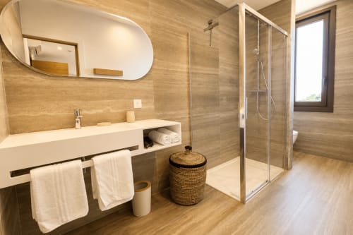 Salle de bains moderne à Villa Alora à Calenzana avec finitions en bois, douche à l'italienne et vue sur les montagnes