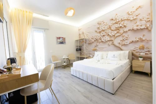 Lussuosa camera presso Aurum Nolana Suites a Pompei con letto bianco, decorazioni murali raffinate e arredi in legno