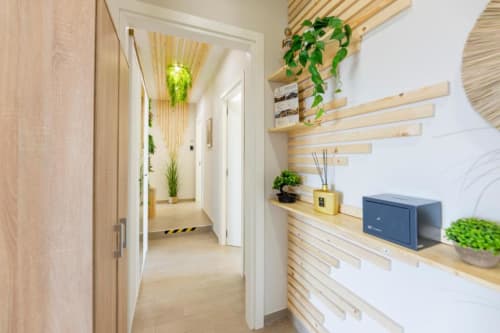 Corridoio moderno dell'Aurum Nolana Suites di Pompei con scaffali in legno, piante e design minimalista