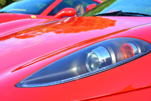 Vibrant red sports car headlight detail showcasing sleek design at Rentalaya luxury rental property in Spain