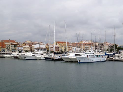 Mediterranean marina with moored sailboats and colorful waterfront buildings in Spain