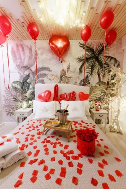 Camera romantica con palloncini rossi, petali di rosa e decorazioni d'amore presso l'Aurum Nolana Suites a Pompei