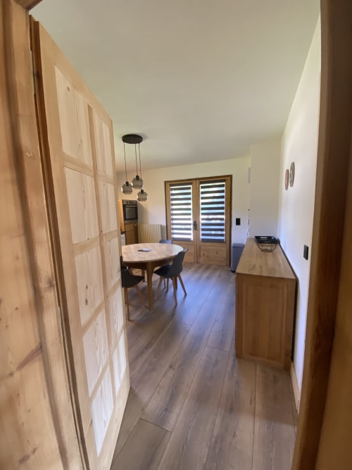 Modern apartment kitchen and dining area at La Ferme des Georgières in Notre-Dame-de-Bellecombe with wooden cabinets and