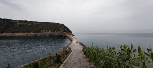 Coastal pathway with sea view and hillside at Origenes Rooms, Italian seaside location