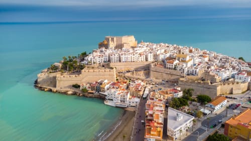 Peniscola's walled Old Town with castle, white buildings, and turquoise Mediterranean Sea