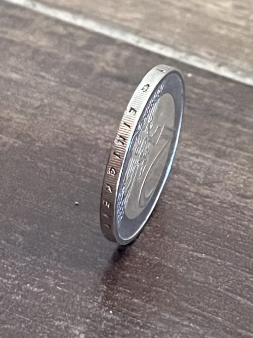 Moneta da un euro in piedi su superficie strutturata all'hotel Habemus di Rocca di Papa, Italia