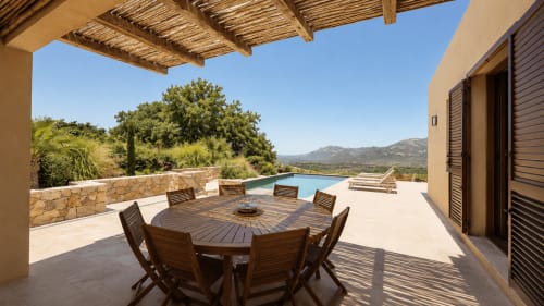 Terrasse de la Villa Alora avec table à manger, piscine et vue sur les montagnes à Calenzana, Corse