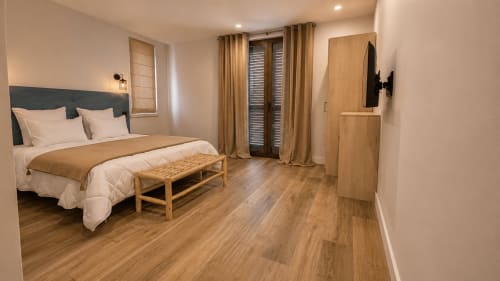 Chambre moderne à la Villa Alora B&B à Calenzana avec parquet, lit, banc et accès au balcon
