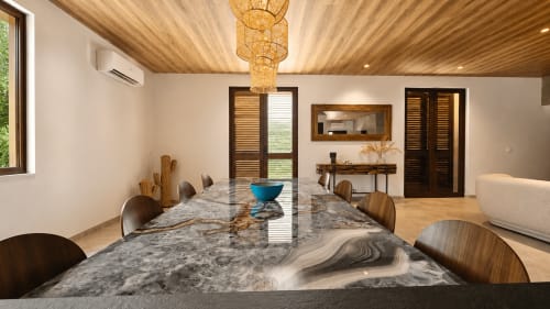 Salle à manger contemporaine de la Villa Alora Calenzana avec table en marbre, chaises en bois et lustre tressé