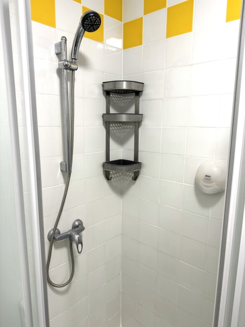 Douche moderne avec pomme de douche pluie et étagère d'angle à la Villa des Palmiers à Villeneuve-sur-Lot
