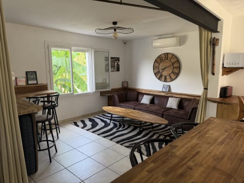 Salon moderne de Villa des Palmiers avec canapé, table en bois, vue jardin et tapis à motif zèbre