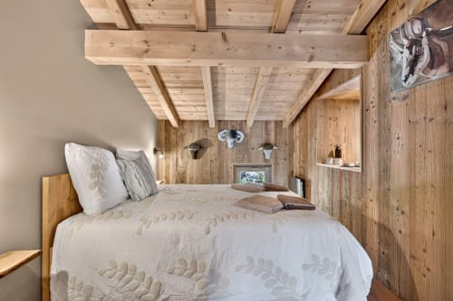 Chambre cosy du chalet L'Alp'In avec poutres apparentes, literie blanche et boiseries rustiques à La Plagne