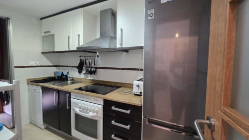 Cocina moderna en el apartamento El Toro Mondrian, Benicàssim, con electrodomésticos de acero inoxidable y acceso a vistas al mar