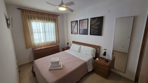 Dormitorio moderno en apartamento frente al mar El Toro Mondrian, Benicàssim con muebles de madera, vistas al mar y diseño contemporáneo