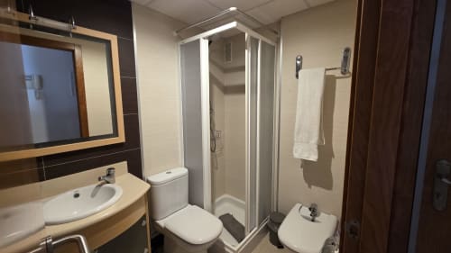Baño moderno con ducha, inodoro, lavamanos y espejo en apartamento frente al mar del hotel MONICA SOCARICI en Benicàssim