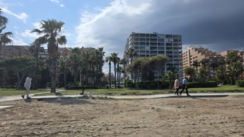 Apartamento frente al mar en Benicàssim con playa de arena, palmeras y edificios modernos de fondo