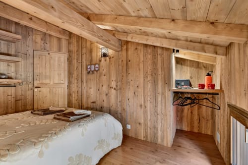 Chambre chaleureuse en bois au B&B L'Alp'In, La Plagne, avec murs en pin, literie blanche, rangements et vue sur le jardin
