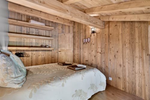 Chambre douillette en bois à L'Alp'In B&B à La Plagne avec murs en pin, lit double, rangements et décor alpin rustique