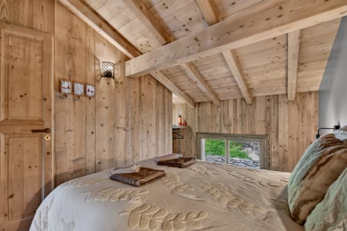 Chambre spacieuse en bois à L'Alp'In B&B à La Plagne avec poutres apparentes, lit queen-size et vue sur le jardin