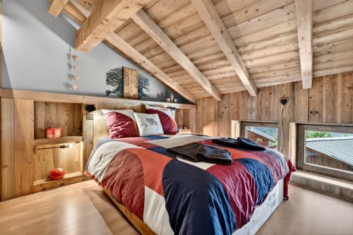 Chambre montagnarde douillette au chalet L'Alp'In à La Plagne, avec poutres apparentes, linge de lit coloré et vue alpine