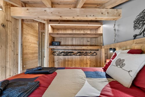 Chambre cosy en bois à L'Alp'In B&B à La Plagne avec poutres apparentes, linge de lit coloré et charme montagnard