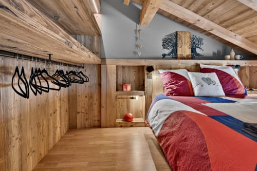 Chambre douillette en bois à L'Alp'In avec literie rouge, poutres apparentes et art mural à La Plagne
