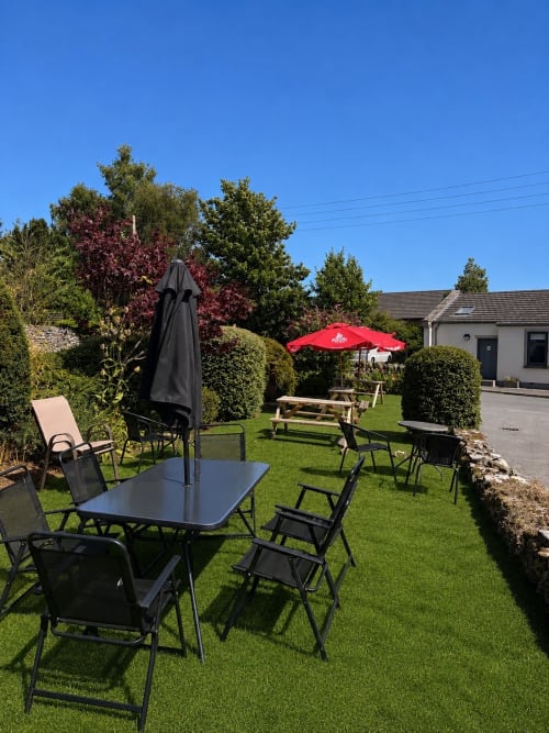 Kings Arms hotel beer garden in Penrith with tables, umbrellas and seating on manicured lawn