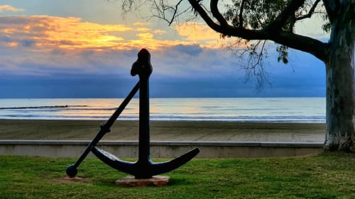 Gran ancla silueteada sobre el césped con vistas a la playa del atardecer en Villa Pilar, Benicàssim