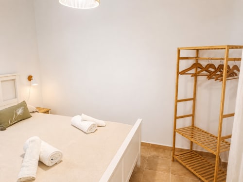 Bright bedroom at Living Sur, Sanlúcar de Barrameda with bed, wooden wardrobe, and fresh white towels