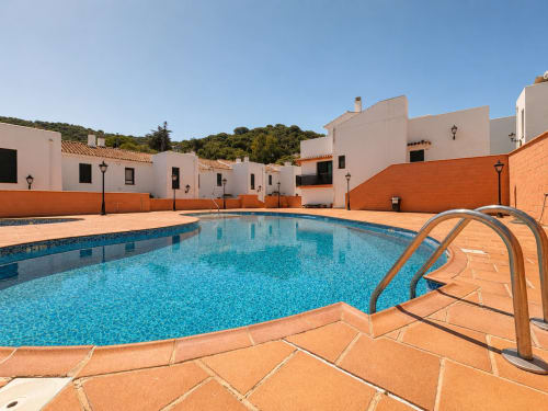 Swimming pool at Living Sur apartments in Sanlúcar de Barrameda with white cottages and orange terrace