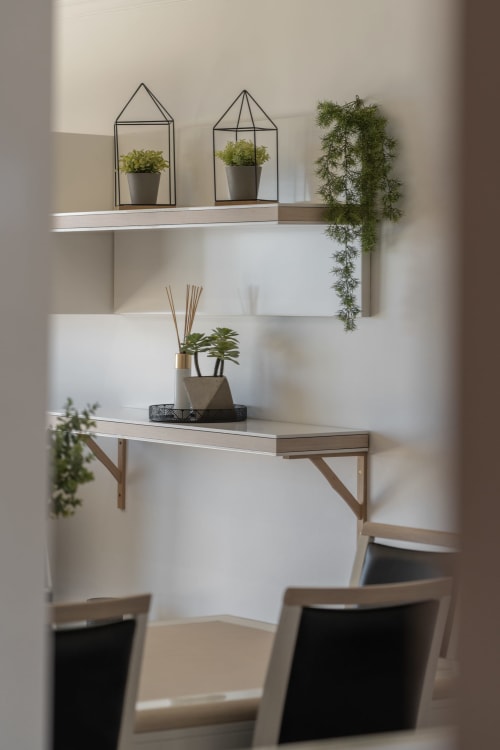 Espaço de trabalho moderno com prateleiras brancas, plantas em vasos e secretária no apartamento Rent-A-Key em Caniço