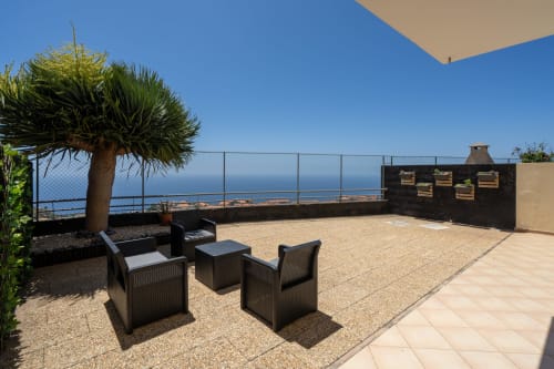 Terraço do apartamento Blue Horizon com vista para o mar, área de estar, palmeira e paisagem oceânica em Caniço