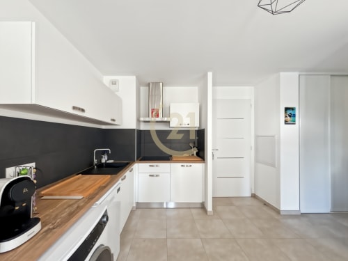 Cuisine blanche moderne avec plan de travail en bois et crédence noire, T2 élégant à Calvi, Corse