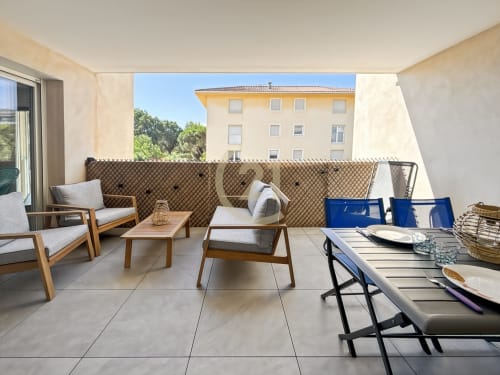 Terrasse spacieuse meublée avec coin salon, table à manger et vue sur la ville, appartement à Calvi