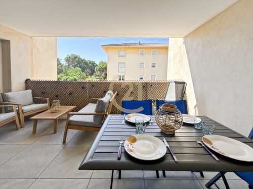 Élégante terrasse avec table à manger et coin lounge avec vue sur le centre-ville de Calvi, L'Île-Rousse