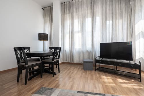 Soggiorno moderno a Milano con zona pranzo, TV a schermo piatto e ampi vetrata con tende di tulle