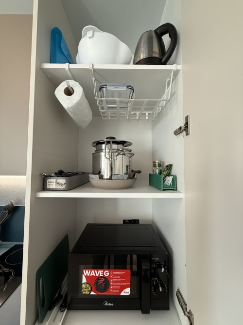 Scaffale bianco nell'appartamento La Casetta dei Ronchi con elettrodomestici da cucina: bollitore, pentola a pressione e microonde