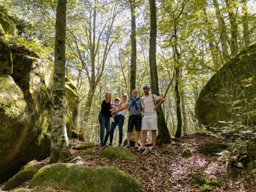 Family hiking through moss-covered forest trail at La casa de la masia, Susqueda, Girona