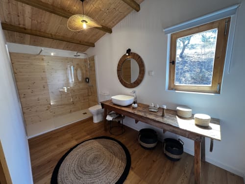 Banheiro moderno na villa Casa do Montado em Corvatos Casas do Monte, Almodôvar, com penteadeira de madeira, espelho redondo e