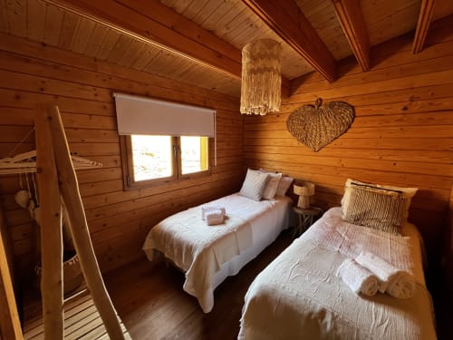 Quarto aconchegante com duas camas de solteiro, decoração de coração trançado e teto rústico na quinta Casa do Montado em Almodôvar