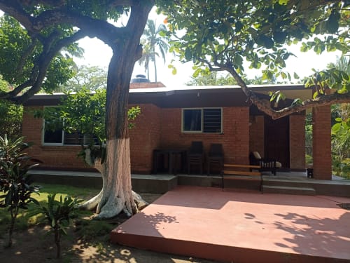 Villa Casa Flais en La Morada, Monte Gordo, México, con arquitectura de ladrillo rodeada de exuberante vegetación