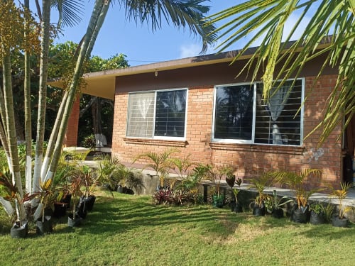 Villa Casa Flais en La Morada con fachada de ladrillo, zona de estar en jardín, plantas tropicales y entrada privada en Monte Gordo