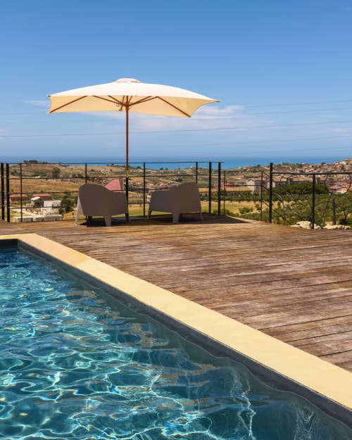 Terrazza piscina di Baglio Capo con ombrellone, lettini e vista sul mare Mediterraneo a Siculiana, Sicilia