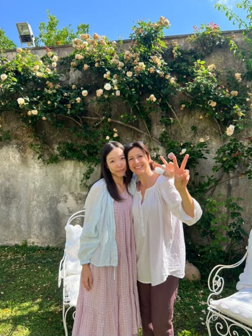 Due donne sorridenti tra le rose fiorite nel giardino della struttura Relais Palazzo Cacace, B&B a Meta di Sorrento