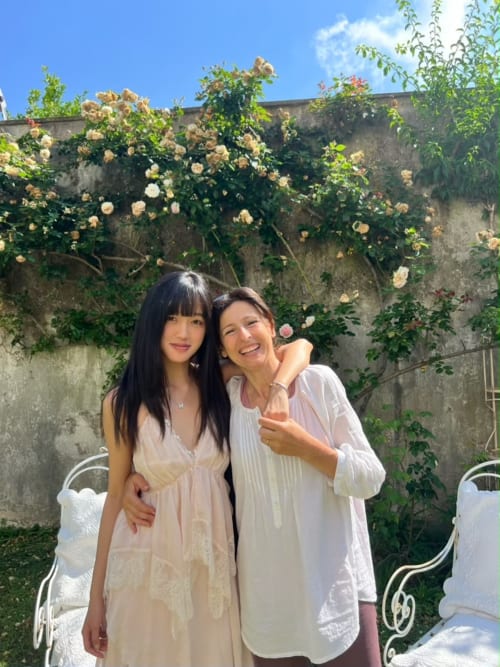 Due donne sorridenti accanto alle viti fiorite del Relais Palazzo Cacace a Meta di Sorrento