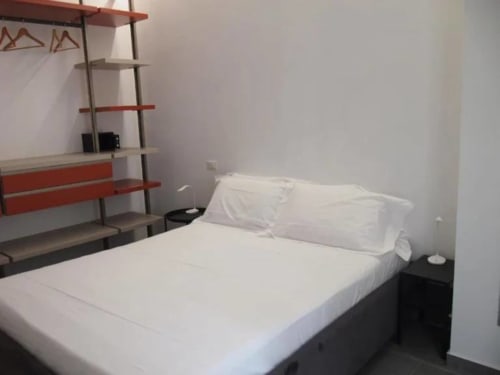 Camera moderna di Vahospitality in Francia con letto, biancheria bianca, scaffale rosso e arredamento minimalista